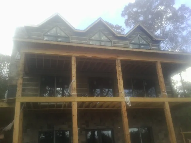 Dormers and porch framing on a large log home under construction — Roof Coating work by our crew in Silver Plume