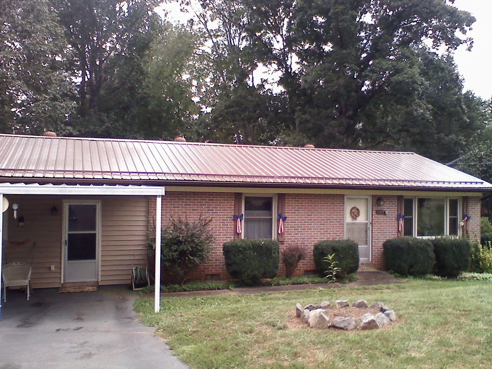 Bronze metal roof and carport on a brick ranch home — Roof Repair work by our crew in Silver Plume
